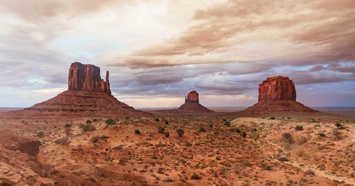 The West and East Mittens and Merrick Butte of Monument Valley under an evening sky